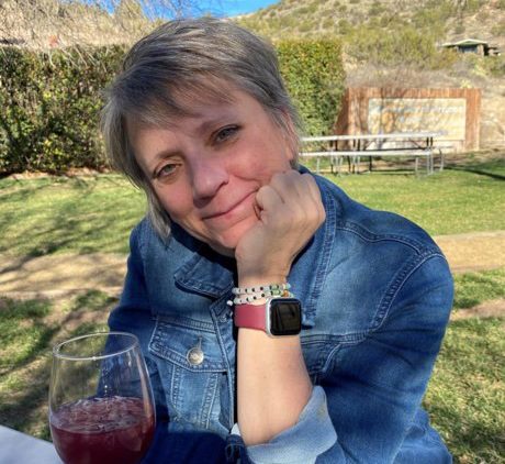 Denise Porchetta at picnic table with glass of wine