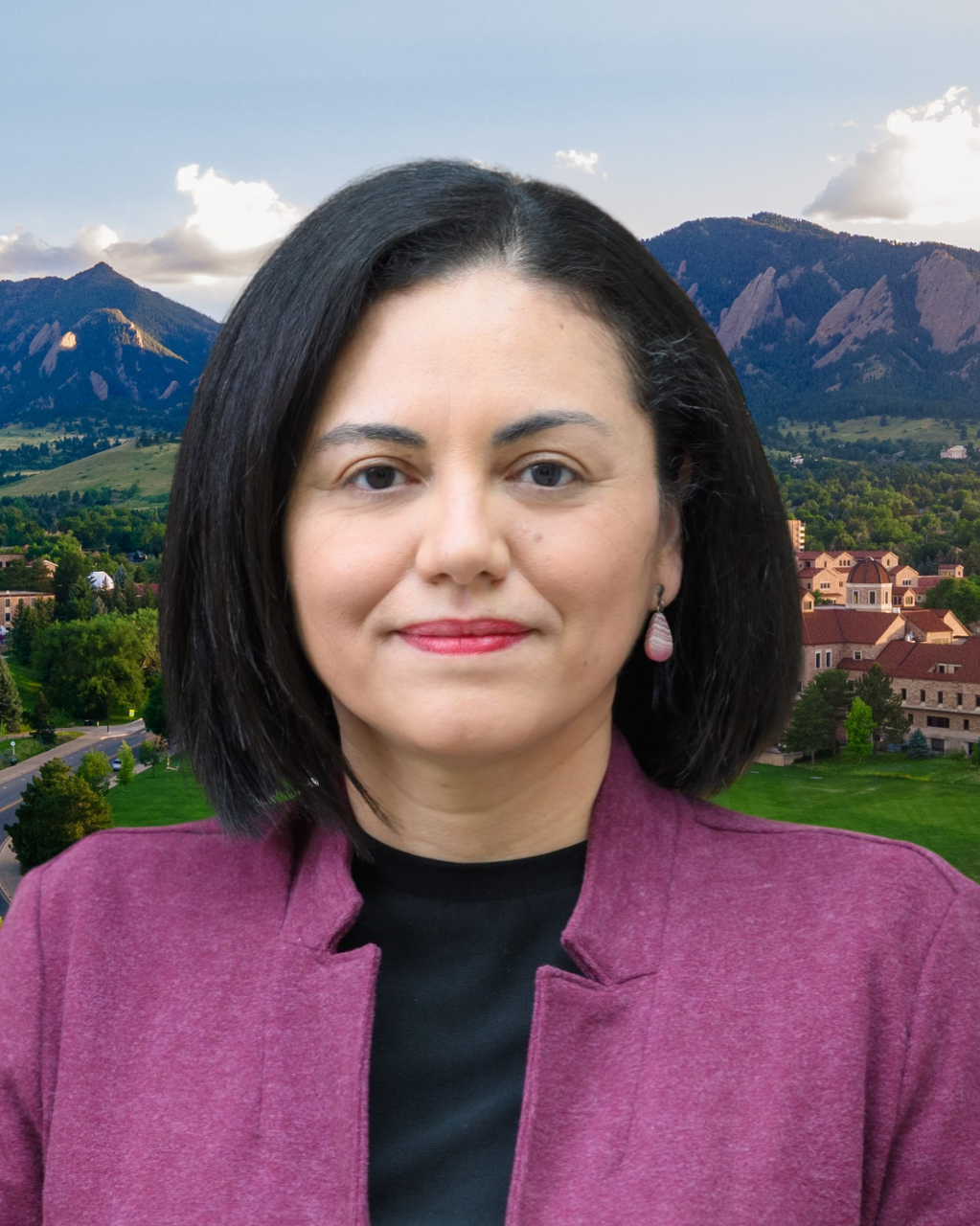 Abby Cordova wears a purple jacket. Behind her, a view of the Boulder Flatirons and CU Boulder campus.