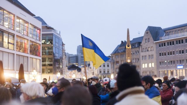 A group of people protest outside of a government building in Ukraine.