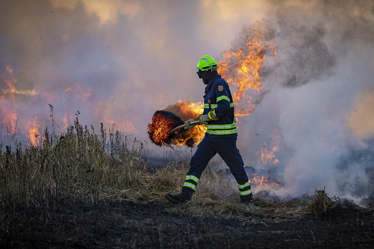 A firefighter works on a grassland fire.