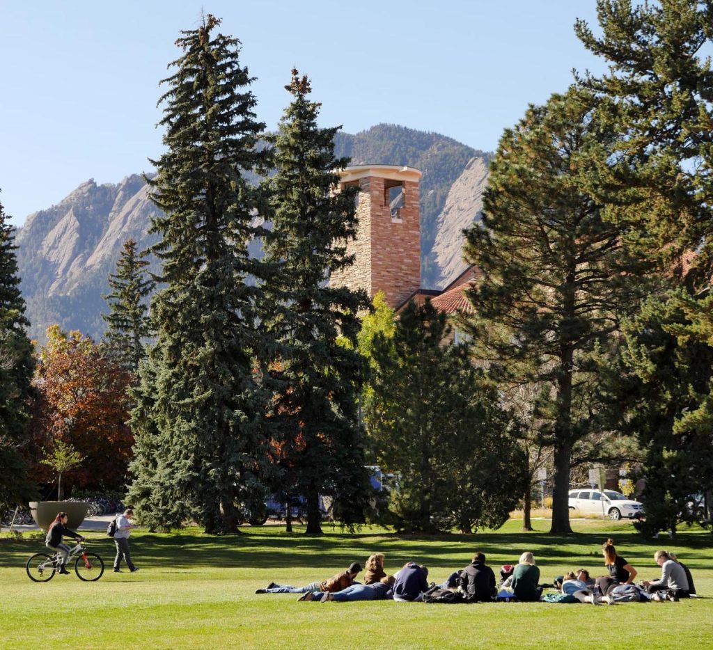 Class outdoors under trees and Flatirons