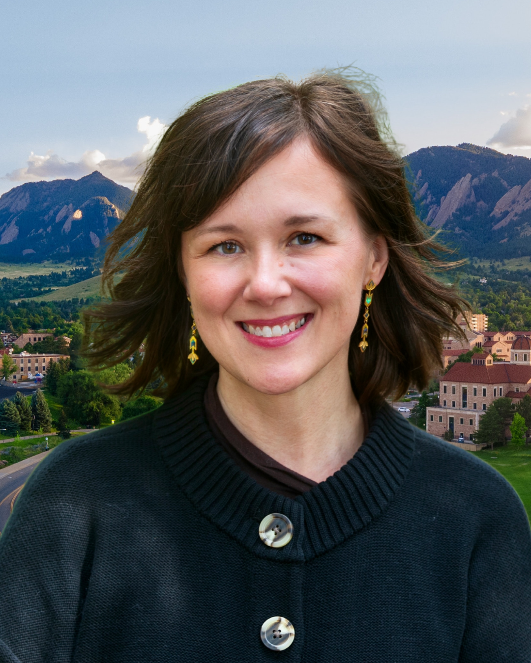 Melissa Walls wears a black buttoned cardigan. Behind her, a view of the Boulder Flatirons.