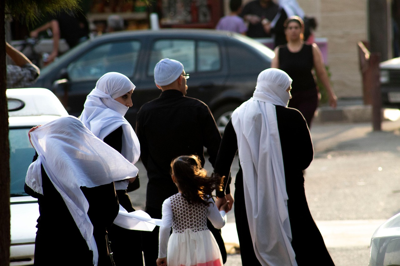 A family looks at oncoming traffic before crossing the street in Syria.