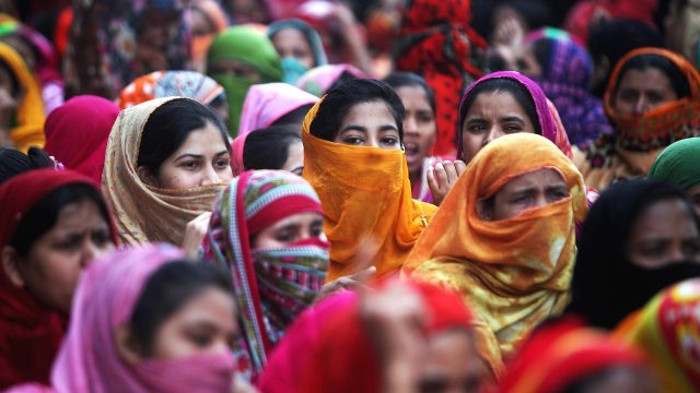 A crowd of Bangladeshi women protest wearing colorful head scarves.