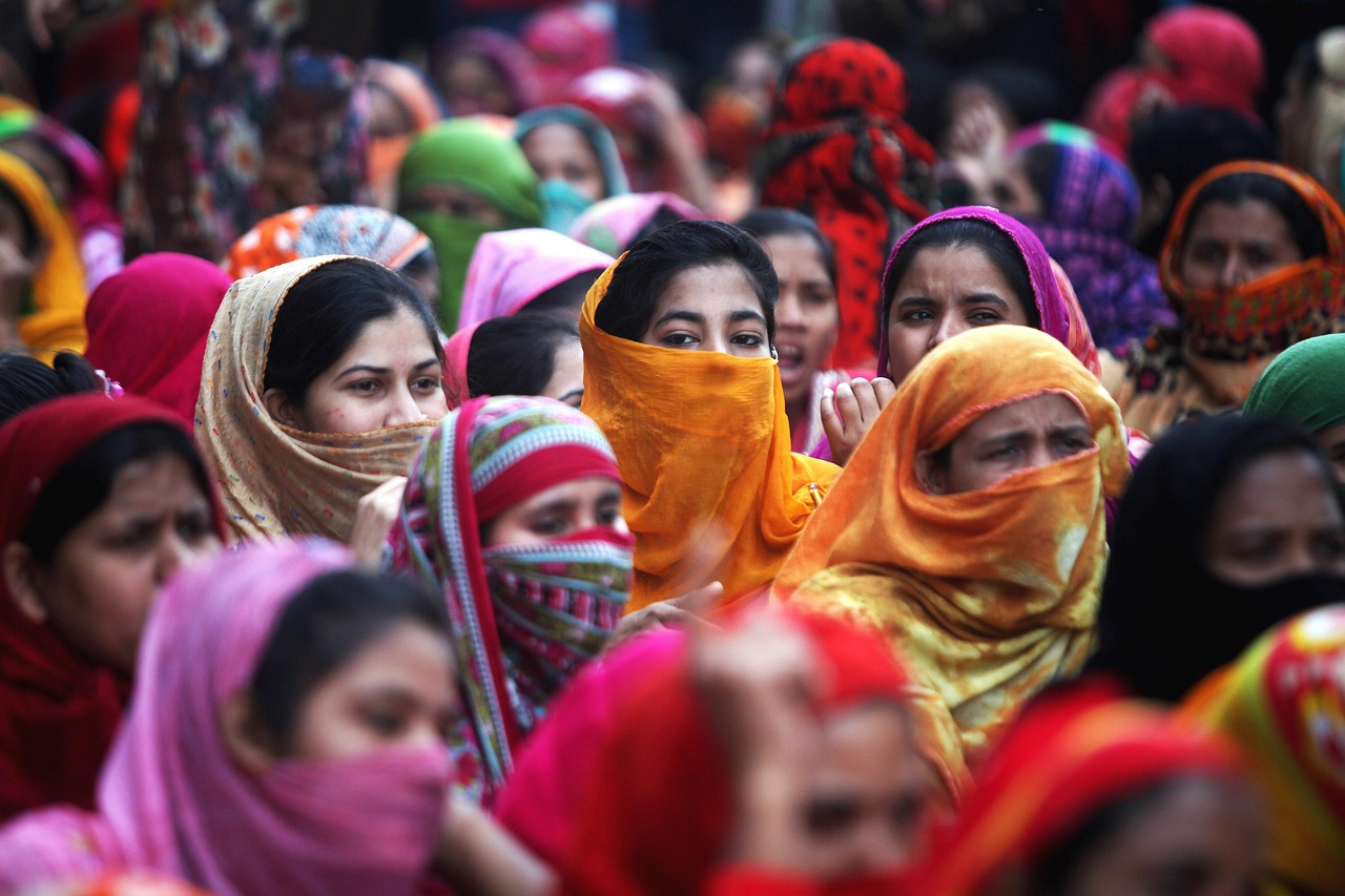 A crowd of Bangladeshi women protest wearing colorful head scarves.