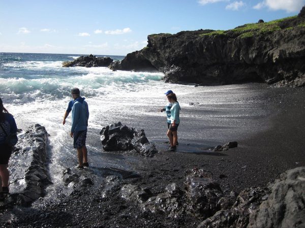 People on rocky Hawaiian coast